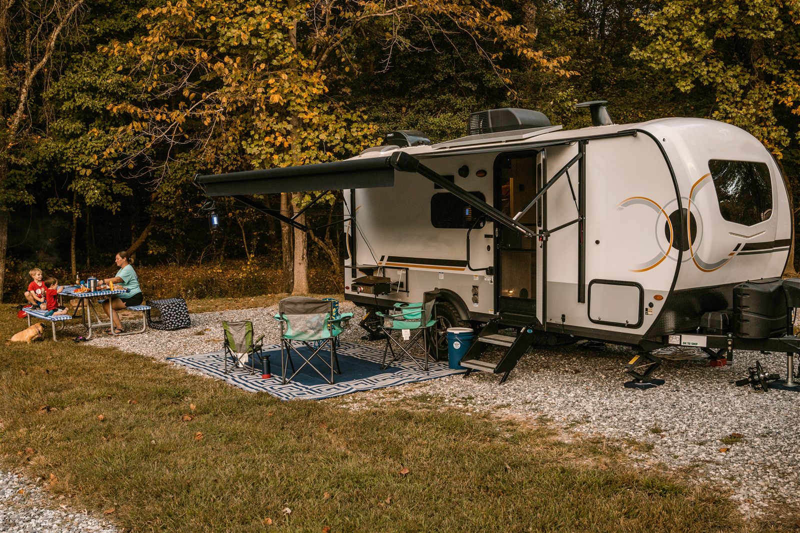 Travel trailer parked at a wooded campsite